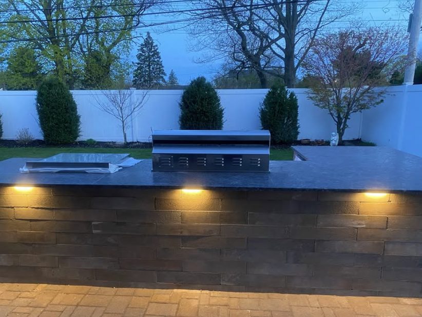 Recessed accent lighting built into a stone hardscape wall