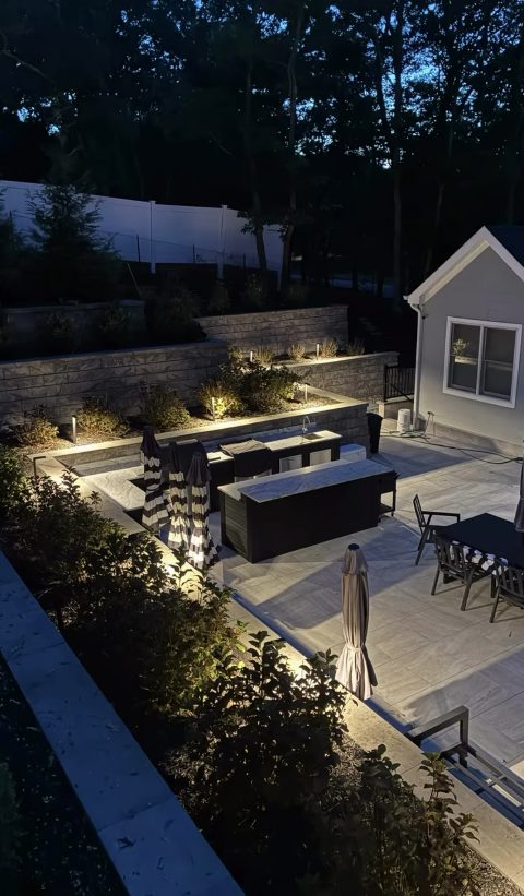 Wide view of a lit patio entertaining space at dusk