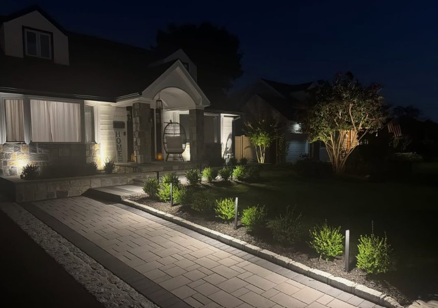 Warmly lit front walkway and entry with string lighting